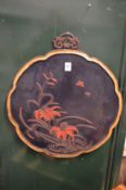 A Japanese lacquer panel with carved decoration.