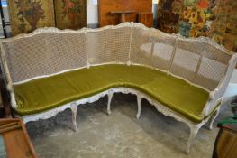 An unusual carved and painted bergere corner settee.