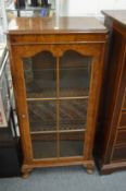 A walnut single door display cabinet.