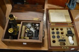 A microscope with accessories together with a box of accessories.