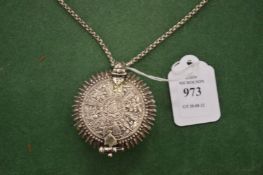 An Eastern embossed white metal circular box and cover on chain.