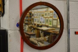 A mahogany circular wall mirror.