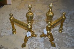 A pair of brass fire dogs.