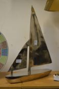 An aluminium model of a sailing boat.