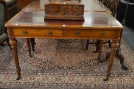 A 19th century walnut two drawer writing table with red leather inset top on turned supports with