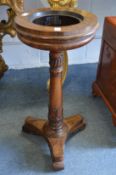 A 19th century rosewood circular jardiniere on column support with tricorn base (lacking liner).
