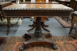A 19th century rosewood fold over card table on turned and carved column support with concave
