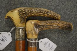 Two Victorian walking sticks with antler handles and silver collars.