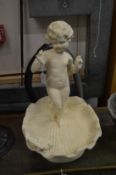 A small cast iron bird bath modelled as a cherub standing in a shell.
