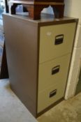 A metal three drawer filing cabinet.