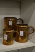 A graduated set of three copper measures.