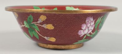 A CHINESE RED GROUND CLOISONNE BOWL decorated with flora and butterflies. 23cm diameter
