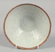 A CHINESE CELADON GLAZE BOWL, with carved floral decoration to the interior, 18cm diameter.