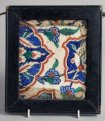 A 16TH CENTURY OTTOMAN IZNIK TILE, painted with foliate motifs and inset within an antique frame,