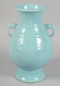 A CHINESE POWDER BLUE GLAZED TWIN-HANDLED VASE with carved decoration to the body, the handles
