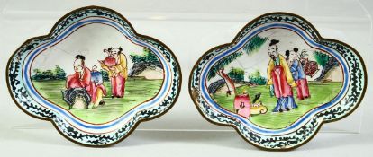 A SMALL PAIR OF CHINESE QUATREFOIL FORM ENAMEL DISHES, painted with figures in a garden, 9cm x 7.