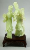 A CHINESE JADE FIGURAL GROUP ON A HARDWOOD STAND, the jade carved as two female figures, mounted