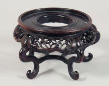 A CHINESE CARVED AND PIERCED CIRCULAR HARDWOOD VASE STAND. (lacking one foot) To fit a vase with
