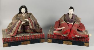 A PAIR OF JAPANESE CARVED AND LACQUERED WOOD MARRIAGE DOLLS, each with embroidered robes and include