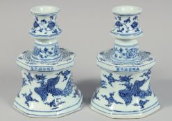 A PAIR OF CHINESE BLUE AND WHITE PORCELAIN CANDLESTICKS each decorated with phoenix and foliate