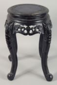 A SMALL CHINESE EBONISED CARVED HARDWOOD STAND, with carved and pierced frieze supported on four