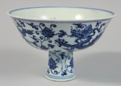 A CHINESE BLUE AND WHITE PORCELAIN PEDESTAL BOWL the exterior decorated with dragon and scrolling