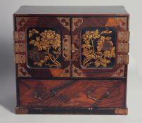 A JAPANESE HARDWOOD TABLE CABINET, with lacquered panels on two hinged doors above a single