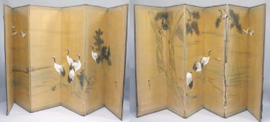 A LARGE PAIR OF JAPANESE SIX PANEL FOLDING SCREENS, each painted with a continuous image of cranes