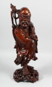 A LARGE CHINESE CARVED HARDWOOD FIGURE OF A SAGE holding a scroll, with inset teeth and eyes, the