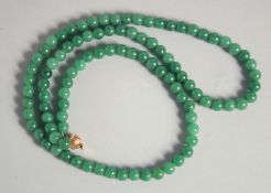 A CHINESE JADE BEADED NECKLACE, with yellow metal clasp (stamped).