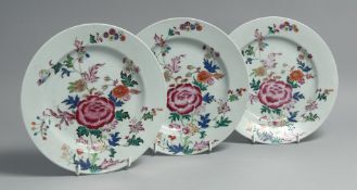 THREE CHINESE FAMILLE ROSE PORCELAIN PLATES, each painted with a vivid floral spray with