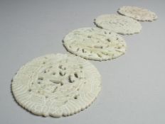 FOUR CHINESE CARVED AND PIERCED HARDSTONE PLAQUES, each approx. 12cm diameter.