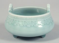A CHINESE CELADON PORCELAIN TRIPOD CENSER, with incised greek key rim above a band of decorative