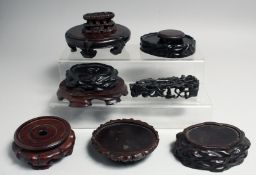 A COLLECTION OF TEN CHINESE CARVED HARDWOOD STANDS, largest 14.5cm diameter, (10).