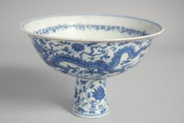 A CHINESE BLUE AND WHITE PORCELAIN STEM CUP, decorated with dragons with a band of characters to the