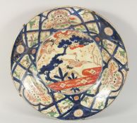 A VERY LARGE JAPANESE IMARI PORCELAIN CHARGER, painted with cranes and foo dogs, 55cm diameter.