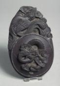 A CHINESE CARVED INKSTONE, with dragon and phoenix, 16cm long.