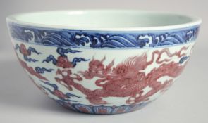 A CHINESE BLUE AND COPPER RED DRAGON BOWL, six-character mark to the interior, 27cm diameter.