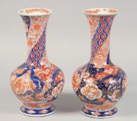 A PAIR OF JAPANESE IMARI PORCELAIN BOTTLE VASES, each painted with phoenix and floral motifs, the