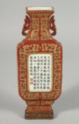 A CHINESE RED GROUND PORCELAIN WALL POCKET VASE, with central panel of calligraphy and two red