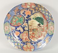 A VERY LARGE JAPANESE IMARI PORCELAIN CHARGER, painted with a large panel of two female figures