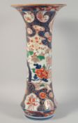 A VERY LARGE JAPANESE IMARI PORCELAIN TRUMPET VASE painted with various flora. 59.5cm high