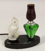 AN ART DECO LAMP, parrot, and scent bottle on an oval base.