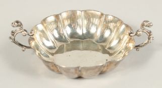 A VICTORIAN SILVER TWO HANDLED DISH 4.25ins diameter. London 1883