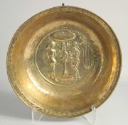 A 17TH CENTURY BRASS ADAM AND EVE CIRCULAR ALMS DISH. 12ins diameter, 2.5ins deep.