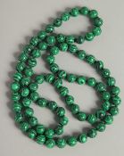 A STRING OF MALACHITE BEADS.