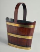 A GOOD GEORGE III MAHOGANY OVAL BRASS RINGED BUCKET with three brass rings and looped wooden