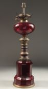 A RUBY GLASS LAMP AND BASE 1ft 9ins high.