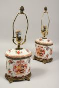 A PAIR OF ARMORIAL PORCELAIN OVAL LAMPS. 16ins high.