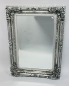 A LARGE DECORATIVE SILVER FRAMED MIRROR 4ftx 2ft 11ins.